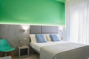 リミニにあるHotel Mon Paysの緑の壁、ベッド付きのベッドルーム1室