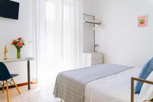 リミニにあるHotel Mon Paysのベッドルーム1室(ベッド1台、デスク、テーブル付)