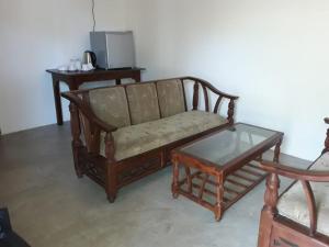 a couch and a coffee table in a living room at Triple Tree Cottage in Tissamaharama