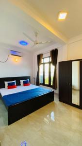 Schlafzimmer mit einem Bett mit blauer Bettwäsche und einem Fenster in der Unterkunft KPN Trinco Holiday Resort in Trincomalee