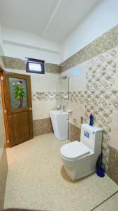 a bathroom with a toilet and a window and a door at KPN Trinco Holiday Resort in Trincomalee
