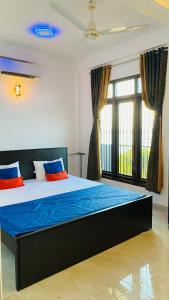 a bedroom with a large bed with blue and orange pillows at KPN Trinco Holiday Resort in Trincomalee