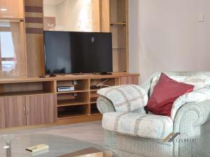 a living room with a chair and a television at Imperial Suites by Evernent in Miri