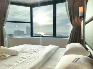 a bed in a room with a large window at Imperial Suites by Evernent in Miri