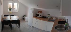 uma cozinha com uma mesa e um micro-ondas em Rooms Jelak em Velika Gorica
