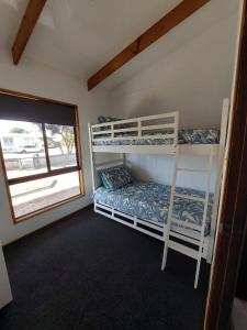 1 Schlafzimmer mit 2 Etagenbetten und einem Fenster in der Unterkunft Karoa in Wallaroo