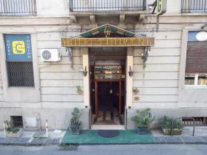 a building with a sign on the front of it at Hotel Touring in Messina