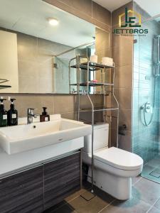 a bathroom with a sink and a toilet and a mirror at Teega Suites By JettBros Johor Bahru in Nusajaya