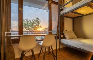 Pokój z łóżkiem piętrowym i balkonem z widokiem na okolicę w obiekcie The Trippy Tribe Extended w mieście Bir