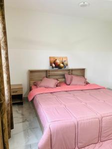 een roze bed met roze kussens in een slaapkamer bij Jabal almumsi in Rasīs