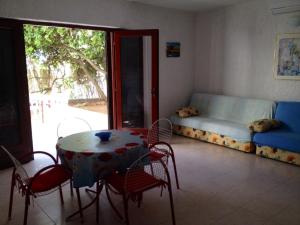 a room with a table and chairs and a couch at Apartments Sugar in Mandre