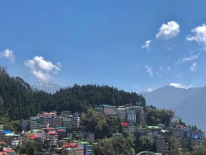 une ville sur une colline avec des montagnes en arrière-plan dans l'établissement ALL SEASONS HOTEL, à Gangtok