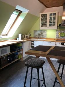 una cucina con tavolo e due sgabelli di Kösters Huus - Schöne Ferienwohnung mit Balkon a Beverstedt