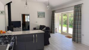 a kitchen and living room with a couch and a table at Cornish Billys Barn in Penzance