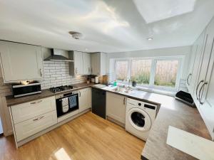 a kitchen with white cabinets and a washer and dryer at RedButt House, Freshwater, 3 Bedrooms, WiFi, Garden in Freshwater