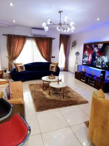 a living room with a couch and a tv at HOMEDALES Freedom Way LEKKI Phase1 LAGOS in Lekki
