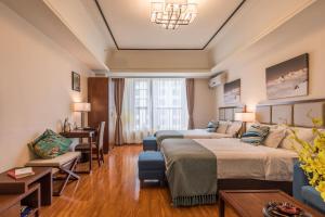 um quarto de hotel com duas camas e um sofá em Livetour Hotel Luogang Wanda Plaza Guangzhou em Guangzhou