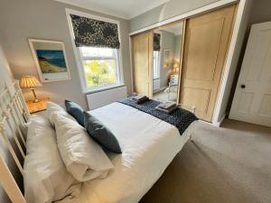 ein großes Bett in einem Zimmer mit Fenster in der Unterkunft RedButt House, Freshwater, 3 Bedrooms, WiFi, Garden in Freshwater