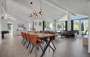 Beautiful Home In Glesborg With Wifi في Glesborg: غرفة طعام وغرفة معيشة مع طاولة وكراسي