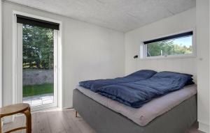 Beautiful Home In Glesborg With Wifi في Glesborg: سرير في غرفة مع نافذة كبيرة