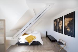 a white bedroom with a bed and a staircase at BIG MAMA free parking in Colmar