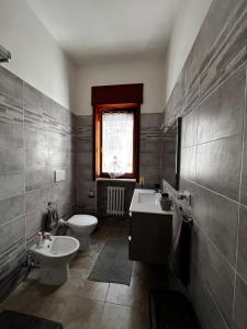 een badkamer met een wastafel, een toilet en een raam bij A casa di Mary in Calimera