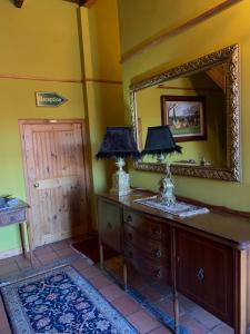 a room with a mirror and a dresser with lamps on it at Port Wine Guesthouse in Calitzdorp