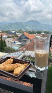 una bandeja de bollería en una mesa con un vaso de leche en Amarillo Lembang en Lembang