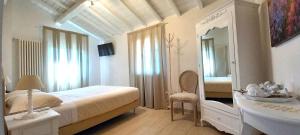 a white bedroom with a bed and a mirror at La Corte Country Rooms in Modena