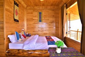 薩帕的住宿－Hmong Eco Villas，木制客房内的一间卧室,配有一张床