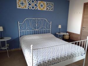 a bedroom with a white bed with blue walls at Good Morning Etna in Bronte
