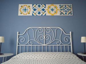 a bedroom with a bed with a blue wall at Good Morning Etna in Bronte