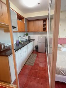 a kitchen with white cabinets and a red tile floor at Pearl Of The Orient Tower, in front of US Embassy in Manila