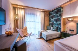 a living room with a bed and a couch at Hotel zur Pfeffermühle in Sankt Anton am Arlberg
