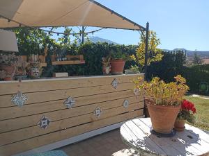 a patio with potted plants on a table with an umbrella at Good Morning Etna in Bronte