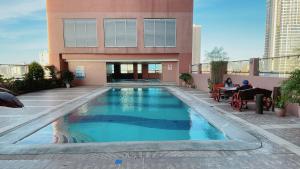 a swimming pool in front of a building at Pearl Of The Orient Tower, in front of US Embassy in Manila