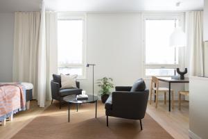 sala de estar con 2 sillas, 1 cama y 1 mesa en Noli Malmi en Helsinki