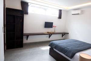 Un dormitorio con una cama y un escritorio con una computadora. en Sare Homestay and Artspace Sanur, en Sanur