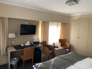 een hotelkamer met een bed en een bureau bij Hotel Atlas in Zeebrugge