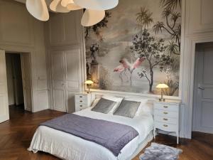 1 dormitorio con 1 cama y una pintura de flamencos en Domaine des Longrais, en Saint-Thurial
