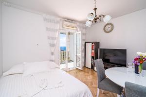 1 dormitorio con 1 cama y 1 mesa con sillas en Apartment Debos, en Dubrovnik