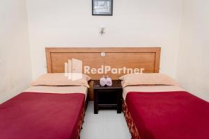 Ein Bett oder Betten in einem Zimmer der Unterkunft Cherry Pink Hotel Medan Mitra RedDoorz