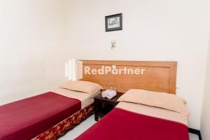 Ein Bett oder Betten in einem Zimmer der Unterkunft Cherry Pink Hotel Medan Mitra RedDoorz