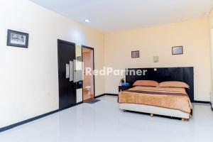 Ein Bett oder Betten in einem Zimmer der Unterkunft Cherry Pink Hotel Medan Mitra RedDoorz