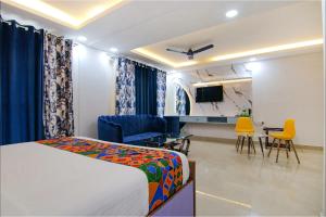 1 dormitorio con 1 cama y sala de estar con sillas en FabHotel Satyam International, en Noida