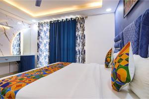 1 dormitorio con cama blanca y cortinas azules en FabHotel Satyam International, en Noida