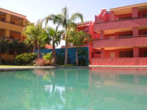 uma piscina em frente a um edifício com palmeiras em Arona 2 - 5208 em Mar de Cristal