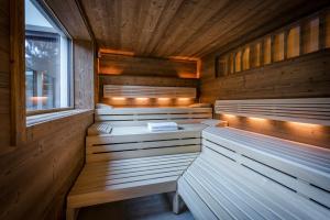 sauna z drewnianymi ścianami i ławkami oraz oknem w obiekcie "Quality Hosts Arlberg" Hotel zur Pfeffermühle w mieście Sankt Anton am Arlberg