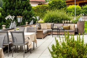un patio con divano, tavoli e sedie. di "Quality Hosts Arlberg" Hotel zur Pfeffermühle a Sankt Anton am Arlberg