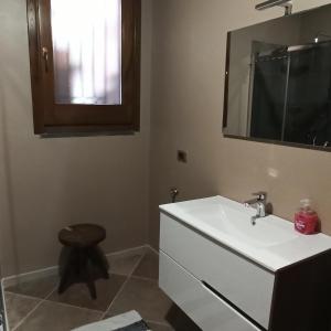 La salle de bains est pourvue d'un lavabo, d'un tabouret et d'un miroir. dans l'établissement La Circumetnea Home, à Catane